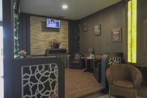 a waiting room with chairs and a tv on a wall at RedDoorz Plus near Pantai Coastarina 2 in Batam Center