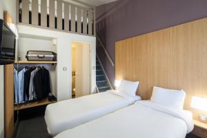two white beds in a room with a closet at B&B HOTEL Troyes Barberey in Troyes +36 photos