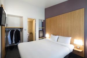 een slaapkamer met een groot wit bed en een kast bij B&B HOTEL Troyes Barberey in Troyes