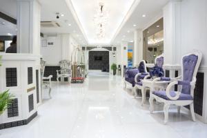 um salão com cadeiras roxas e um lustre em White Fort Hotel em Dubai