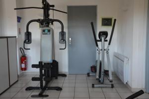 a gym with three exercise bikes in a room at Hotel Albizzia in Valras-Plage