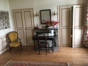 a room with a table and two chairs and a mirror at Château de Villers-Châtel in Villers-Châtel +7 photos