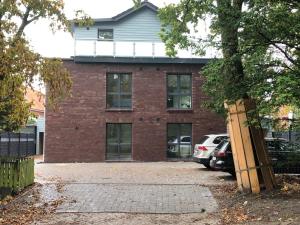 un edificio de ladrillo con coches estacionados frente a él en Apartment Strandperle, en Aurich