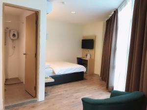 a small room with a bed and a mirror at Tras Mutiara Hotel Bentong in Bentong