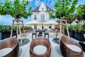 un patio con sillas y mesas frente a un edificio en Welcome Hotel Neckarsulm en Neckarsulm