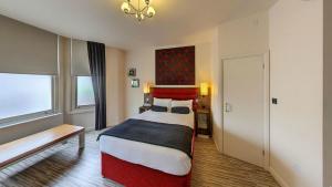 a bedroom with a bed and a dresser at Simply Rooms & Suites in London