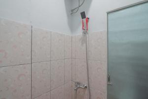 uma casa de banho com um chuveiro e uma porta de vidro em RedDoorz near RSUD Dr. Abdul Aziz em Singkawang
