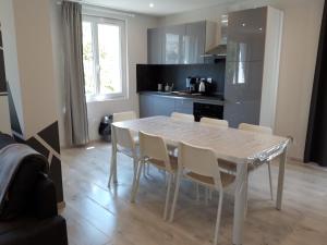 cocina con mesa blanca y sillas en Maison Saint Matteo, en Lourdes