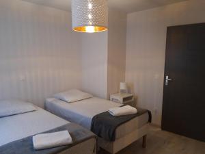 - une chambre avec deux lits jumeaux et une lumière dans l'établissement Maison Saint Matteo, à Lourdes