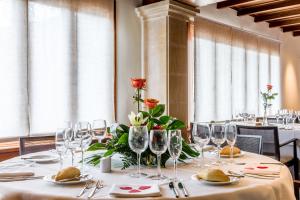 a dining room with a table with wine glasses at Hotel Cala Sant Vicenç - Adults Only in Cala de Sant Vicenc