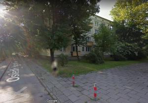 a person walking down a street next to a building at Lovely Madly Apartment in Krakow