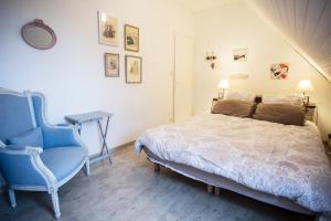 a bedroom with a bed and a blue chair at La Maison Bleue in Baden