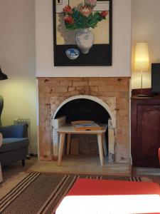 a living room with a brick fireplace with a table at Redruth - 2 bedroom cottage situated in wandiligong in Wandiligong