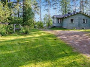 une maison avec une aire de jeux en face d'une cour dans l'établissement Holiday Home Tuuliranta by Interhome, à Nurmes