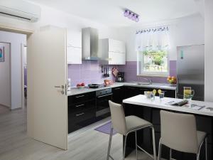 a kitchen with white cabinets and a purple wall at Holiday Home Ana by Interhome in Trget