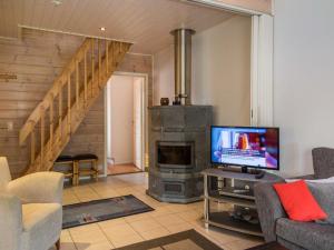 a living room with a fireplace and a tv at Holiday Home Karitahko a 8 by Interhome in Tahkovuori