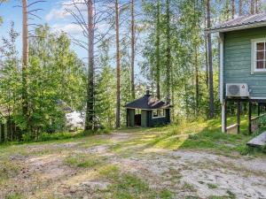 une maison dans les bois à côté d'un chemin de terre dans l'établissement Holiday Home Tuuliranta by Interhome, à Nurmes