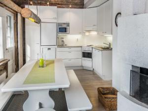 eine Küche mit weißen Schränken und einem weißen Tisch in der Unterkunft Holiday Home Revonaapa b13 by Interhome in Ruka