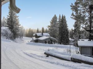 een weg bedekt met sneeuw naast een hut bij Holiday Home Rukaköngäs 25 by Interhome in Ruka