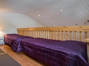 two beds in a room with purple sheets at Holiday Home Karitahko a 8 by Interhome in Tahkovuori