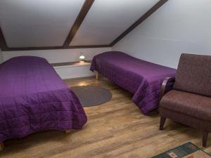 塔庫沃里的住宿－Holiday Home Levähdys by Interhome，紫色床单间内的两张床和一把椅子