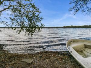 un barco sentado en la orilla de un lago en Holiday Home Mäntyniemi by Interhome, en Luhtanen