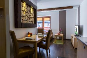 a kitchen and dining room with a table and chairs at udanypobyt Apartamenty Przy Dolinach C i D in Kościelisko