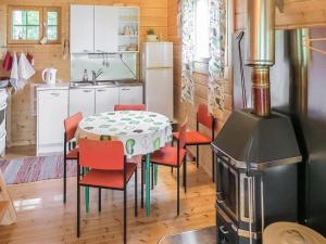 y cocina con mesa, sillas y fogones. en Holiday Home Luisku by Interhome en Punkalaidun