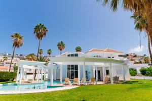 a villa with a swimming pool and palm trees at Casa Palmeras in Adeje