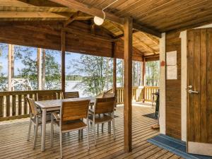una terraza de madera con mesa y sillas. en Holiday Home Mäntyniemi by Interhome, en Luhtanen
