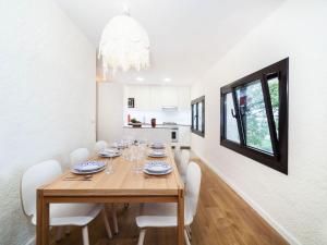 a dining room with a wooden table and white chairs at Holiday Home Paris by Interhome in Calonge