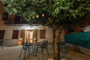 een tafel en stoelen naast een boom in een kamer bij Residenza Europa in Grezzana