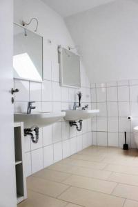 a bathroom with two sinks and a mirror at Dornfelder in Hanhofen