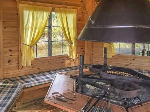 a kitchen with a stove in a log cabin at Holiday Home Merivanamo by Interhome in Haukipudas