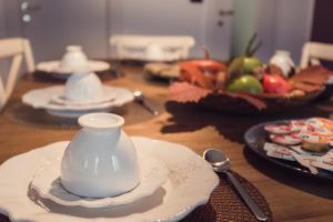 drewniany stół z talerzami i garnkiem do herbaty w obiekcie Residenza Europa w mieście Grezzana