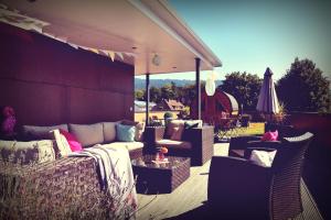 a patio with a couch and chairs and an umbrella at Hotel Nagel in Lindau