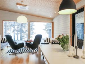 ein Esszimmer mit schwarzen Stühlen und einem Tisch in der Unterkunft Holiday Home Järvenranta by Interhome in Manamansalo