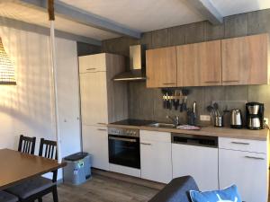 eine Küche mit weißen Schränken, einem Holztisch und einem Tisch in der Unterkunft Lindenhof Habernis in Steinberg
