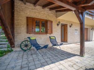 two chairs on a patio in front of a house at Holiday Home Lady Lavender by Interhome in Mrkopalj