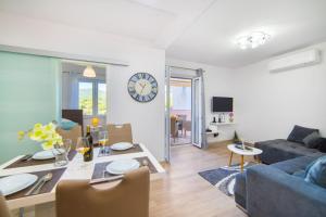 a living room with a blue couch and a clock on the wall at Apartment Karlo - Grad Ploče, Croatia in Ploče