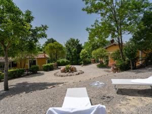 a courtyard with two white chairs and a building at Holiday Home Villa Lavinia by Interhome in Montevarchi