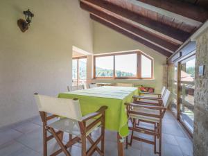 a dining room with a green table and chairs at Holiday Home Lady Lavender by Interhome in Mrkopalj