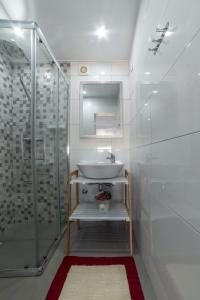 a white bathroom with a sink and a shower at A Casa da Mizi in Praia