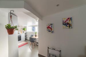 a kitchen with white walls and a table with a plant at A Casa da Mizi in Praia