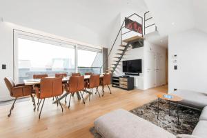 a living room with a dining room table and a large window at Exclusive Penthouse in Ghent in Ghent