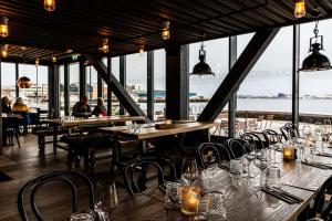 a restaurant with tables and chairs with a view of the water at Smarthotel Hammerfest in Hammerfest