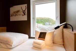 a room with a bed with a lamp and a window at Smarthotel Hammerfest in Hammerfest +43 photos