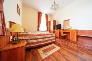 - un salon avec un canapé et un bureau dans l'établissement Pannon Hotel, à Mohács