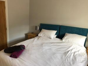 a bedroom with a white bed with a blue headboard at The Milking Parlour, Wolds Way Holiday Cottages, 1 bed cottage in Cottingham