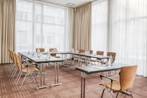 einen Konferenzraum mit Tischen, Stühlen und Fenstern in der Unterkunft IntercityHotel Dresden in Dresden